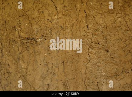 Lime plaster layer removed old antique house clay wall texture. This old house wall made from a mixture of clay, mud and pebbles Stock Photo