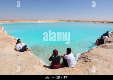 Siwa, Egypt. 26th Mar, 2022. People enjoy themselves by a salt lake at Siwa Oasis in Matrouh Governorate, Egypt, on March 26, 2022. Siwa Oasis lies in Egypt's western desert, some 800 kilometers from Cairo. There are many natural salt lakes on which people can float naturally. Credit: Sui Xiankai/Xinhua/Alamy Live News Stock Photo