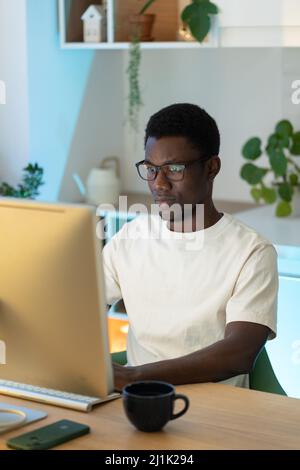 Pensive developer looking at programming code on computer screen Stock ...
