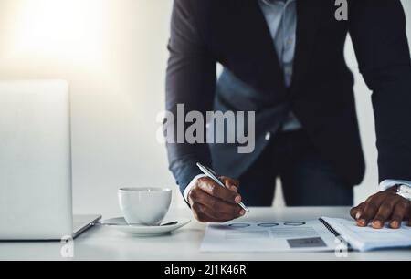 One last thing.... Cropped shot of an unrecognizable young businessman taking notes while working in his modern office. Stock Photo