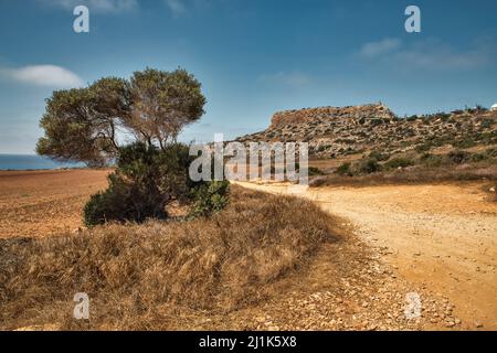 Landscape road to Cape Greco peninsula, Cyprus. It is mountainous peninsula with a national park, rock paths, a turquoise lagoon and a natural stone b Stock Photo