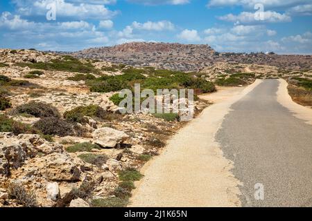 Landscape road to Cape Greco peninsula, Cyprus. It is mountainous peninsula with a national park, rock paths, a turquoise lagoon and a natural stone b Stock Photo