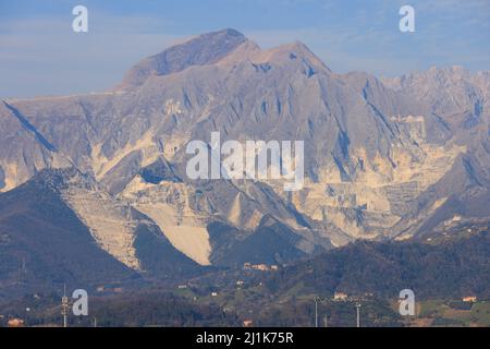 Carrara marble quarry, the white on the mountains behind is quarried faces of marble, as seen from Marina di Carrara, Tuscany, Italy. Stock Photo