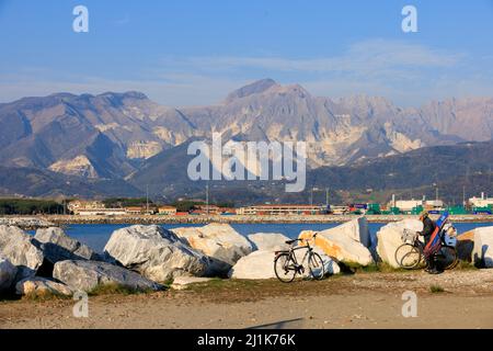 Carrara marble quarry, the white on the mountains behind is quarried faces of marble, as seen from Marina di Carrara, Tuscany, Italy. Stock Photo