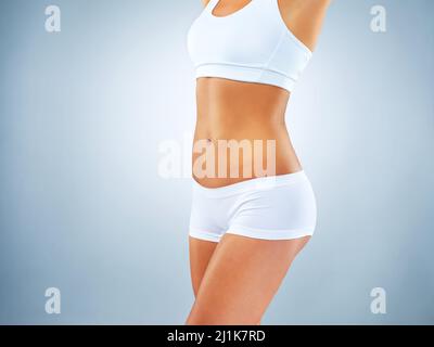 Healthy body keeps you fit. Studio shot of an unrecognizable woman posing against a blue background. Stock Photo