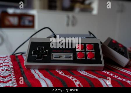 Retro gaming console with classic gamepad controller on a table Stock Photo