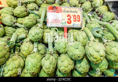 Artichokes alcachofa with a price tag on the shelf in the Mercado de la Paz, Madrid, Spain Stock Photo