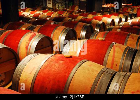 Wine ages in wooden barrels in a cellar in the Napa Valley Stock Photo