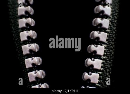 Lock with a gray zipper on black clothes close-up. Jacket clasp Stock Photo