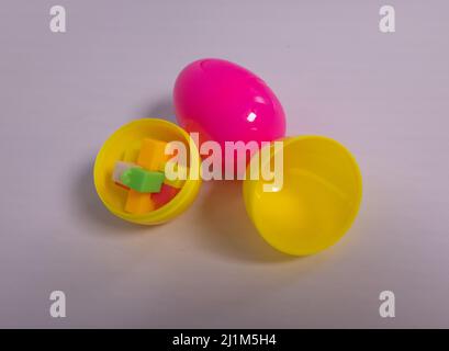 Easter eggs on white background. One egg is open to show there is a toy inside. Stock Photo