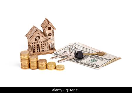 Wooden house, dollars, coins and keys on a white background Stock Photo