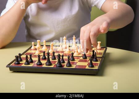 a child makes a move with a chess piece in close-up Stock Photo