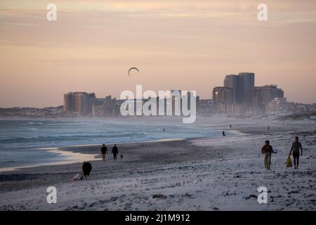 Cape Town, South Africa. 26th Mar, 2022. People walk on Sunset Beach at sunset in Cape Town, South Africa, on March 26, 2022. Credit: Lyu Tianran/Xinhua/Alamy Live News Stock Photo