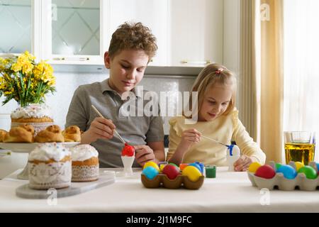 Brother and sister are painting easter eggs. Stock Photo