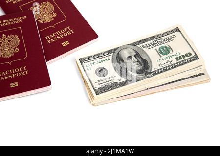 A stack of hundred dollar bills and passports on a white background Stock Photo