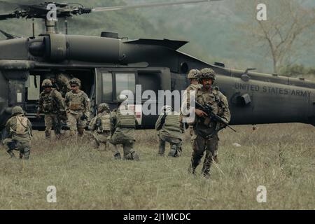 U.S. Army Soldiers assigned to Company D, 2nd Battalion, 27th Infantry Regiment, 3rd Brigade, 25th Infantry Division, and Philippine Army Soldiers assigned to the 1st Brigade Combat Team take their positions as U.S Army senior leaders arrive during a combined live fire exercise in support of Salaknib at Colonel Ernesto Rabina Air Base in Philippines, March 21, 2022. Nearly 1,100 U.S. Army Pacific Soldiers are participating in Salaknib alongside their Philippine counterparts to improve interoperability and strengthen our partnership across the Indo‐Pacific. (U.S. Army photograph by SPC Joshua O Stock Photo