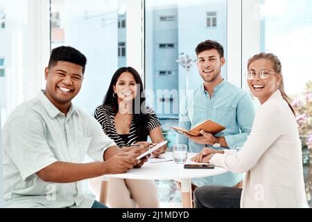 Were the team you need. Cropped portrait of a group of young business colleagues gathered around a table in their office. Stock Photo