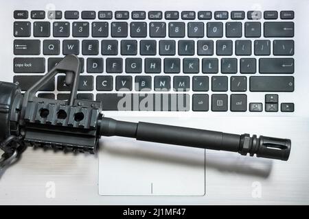 Cyber Warfare. Machine gun on keyboard computer. Fake news. Hybrid war media influence public opinion. Data security cyber war terrorism threat Stock Photo