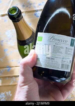 Paris, France - Jan 3, 2022: POV male hand holding bottle with Bio Prosecoo biological sparkling wine - manufactured by Valdoz Stock Photo