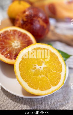 Sicilian sweet juicy yellow and red blood oranges with green leaves close-up Stock Photo