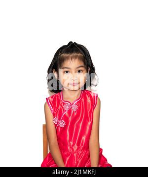 picture of beautiful liitle girl in red chinese dress sitting on chair Stock Photo