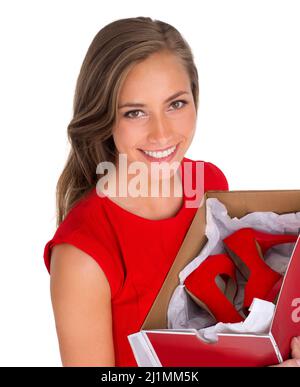 She keeps up to date with the latest fashion trends. High angle shot of an attractive young woman holding a box of new high heels against a white Stock Photo
