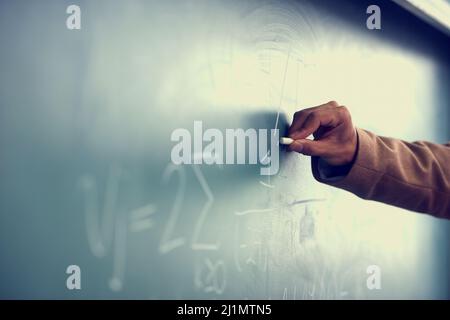 Its all greek to me. Cropped image of a teacher writing a formula on a blackboard. Stock Photo