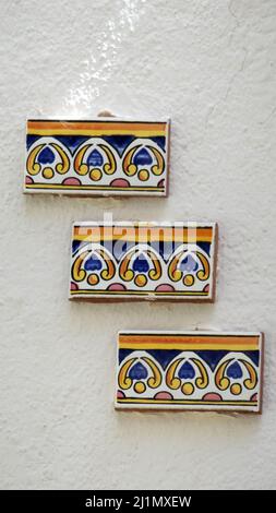 Decorative tile cuttings on whitewashed wall in Andalusian village house Stock Photo
