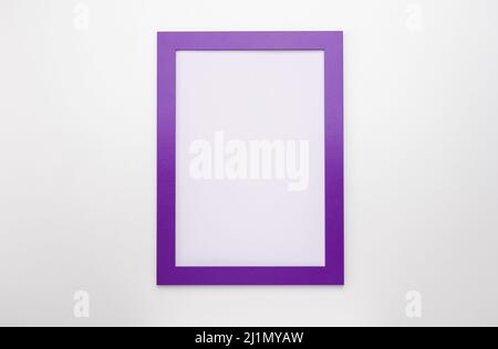 upright photo frame mockup on white wall. purple blank diploma frame on white wall background. Picture frame mockup. blank diploma frame on white wall Stock Photo