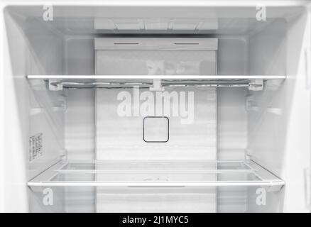 Opened empty refrigerator. Refrigerator open empty fridge inside interior. close up on empty refrigerator with door open. New clean refrigerator. Stock Photo