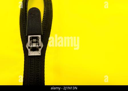 Zip lock on yellow clothes. Jacket clasp. Zipper Stock Photo