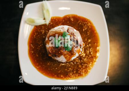 A plate of Chinese BBQ pork on rice with gravy on top. Stock Photo