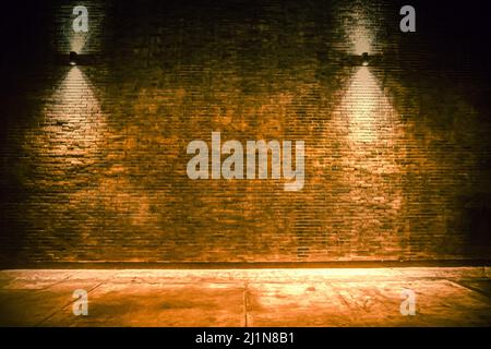 old room with brick wall, grungy background . brick wall with bulb lights lamp. nice brick show room with spotlights. Background of an empty corridor Stock Photo