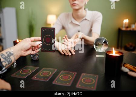 Close up of female fortune teller reading tarot cards for young woman visiting at seance, copy space Stock Photo