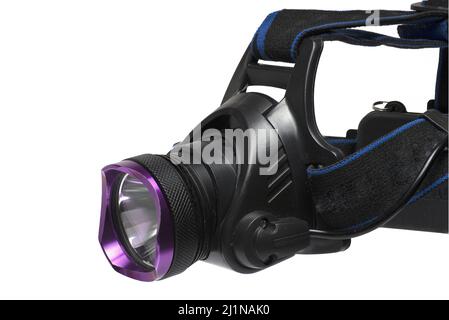 Close up of professional big massive metal head lamp searchlight with black straps for hand free illumination of area while walking and working on whi Stock Photo