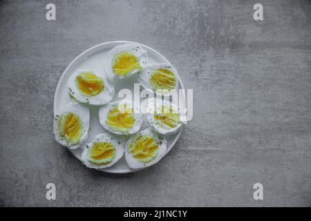 halves of a boiled eggs on a plate with space for text Stock Photo