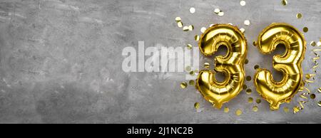 Yellow foil balloon number, number thirty three on a concrete background. 33rd birthday card. Anniversary concept. for anniversary, birthday, new year Stock Photo