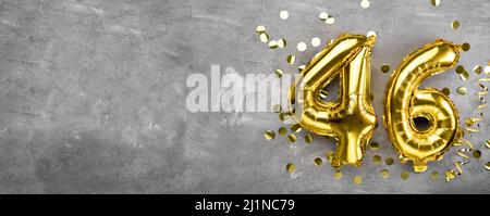 Yellow foil balloon number, number forty six concrete background. Greeting card with the inscription 46. Anniversary concept. for anniversary Stock Photo