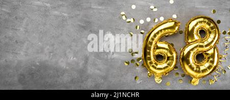 Yellow foil balloon number, number sixty eight on a concrete background. Greeting card with the inscription 68. Anniversary concept. for anniversary Stock Photo