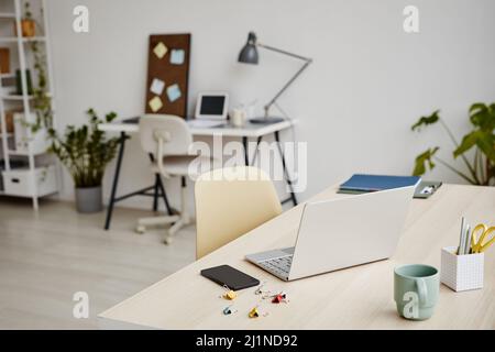Background image of opened laptop on desk in comfortable office interior, no people Stock Photo