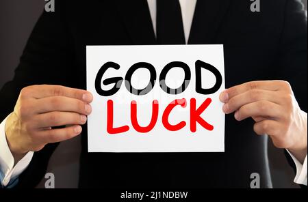 Man holding blackboard in hands and pointing the word GOOD LUCK Stock Photo
