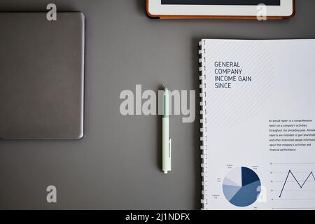 Minimal flat lay of business tools on grey desk, focus on pen and finance notebook Stock Photo