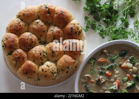 Dinner rolls with stewed chicken and vegetables. Home baked golden brown color dinner rolls fresh from the oven, glazed with butter, served along with Stock Photo
