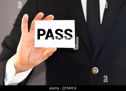 PASS, word on the card shown by a man, vintage tone. Stock Photo