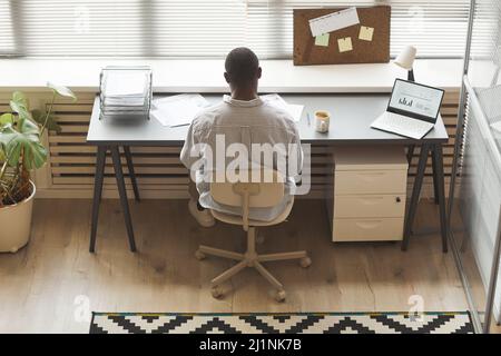 Minimal top view of black entrepreneur analyzing documents while working by window in office, copy space Stock Photo