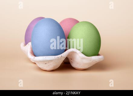 Multicolored dyed Easter eggs in carton box on beige background. Celebration tradition concept. High quality photo Stock Photo