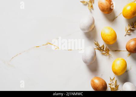 Elegant Easter flat lay composition. Luxury bronze Easter eggs and golden branches on marble table. Top view, flat lay, copy space. Stock Photo