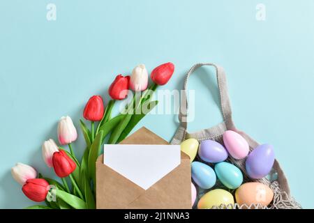 A beautiful bouquet of tulips with a string bag containing painted eggs. Stock Photo