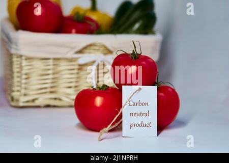 Carbon neutral product label on tomatoes. Carbon labeling. Basket of vegetables on background. Net zero carbon, emissions free. Organic farm products Stock Photo