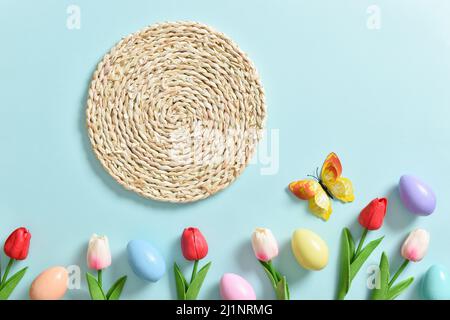 Spring composition with tulip flowers, Easter colored eggs and butterflies. Stock Photo